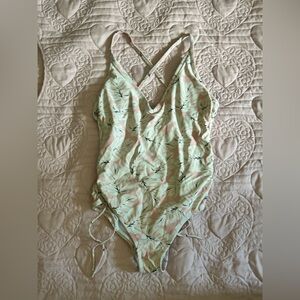 A flower swim suit with pink and white flowers and black leaves